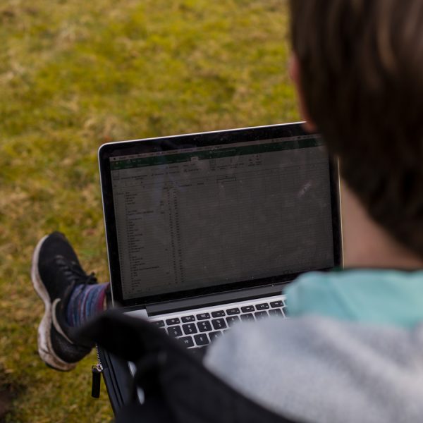 To spejderledere viser en færdselstavle for en gruppe børn